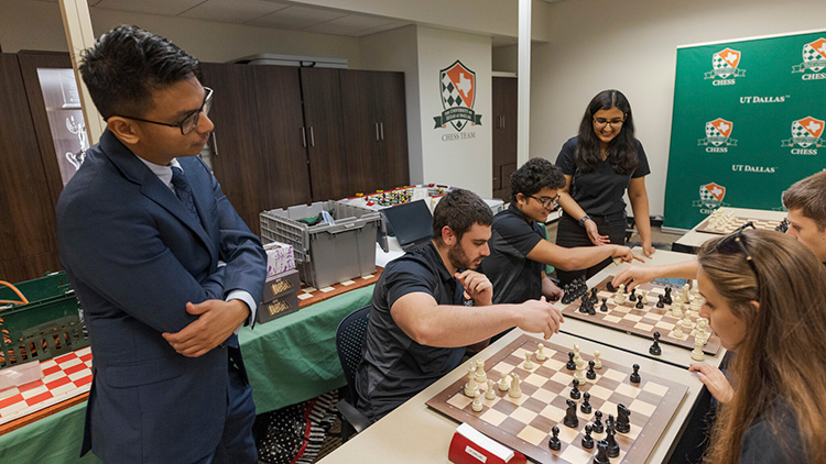 Chess Team coach Julio Catalino Sadorra watches team members play.